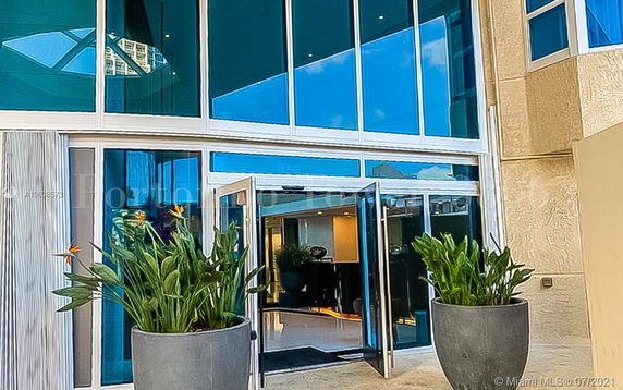 Front view of a building entrance with large glass doors and windows.