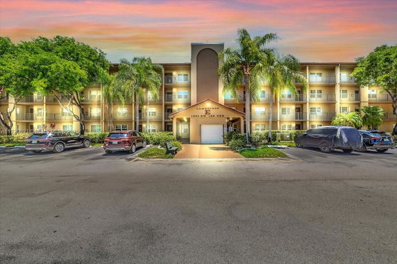 Front view of a multi-story residential building with balconies and a central entrance.