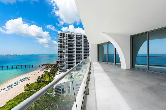 Balcony of a high-rise building overlooking the ocean and beach.