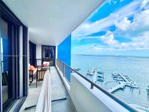 View from a balcony overlooking a body of water with docks and boats.