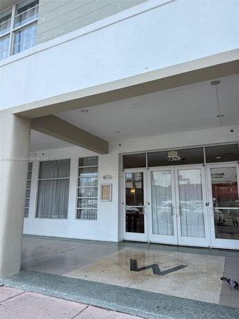 Front view of a building entrance with glass doors and windows.