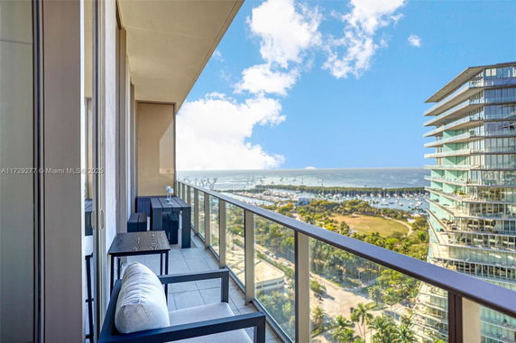 High-angle view from a balcony overlooking a scenic landscape with buildings and water.