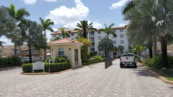 Front view of a multi-story residential building with a gated entrance.