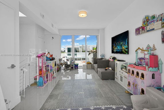 Indoor play area with toys, a couch, and a TV.