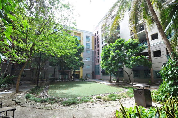 View of a building complex from a courtyard with trees and green spaces.