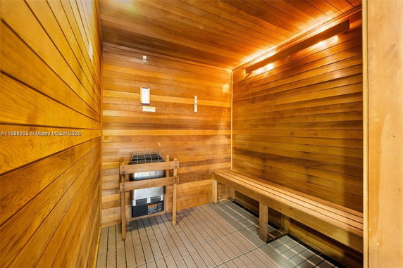 Interior view of a wooden sauna room with benches and a heater.