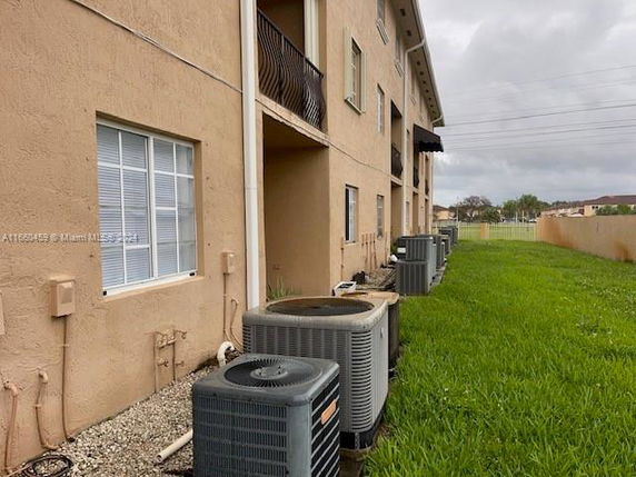 Side view of a multi-story building with air conditioning units along the wall.