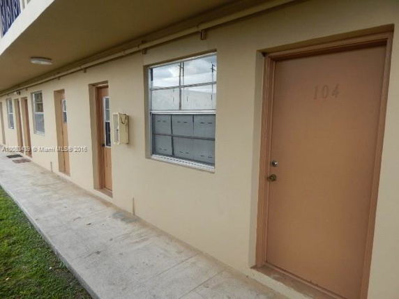 Front view of a building with multiple doors and windows in a row.
