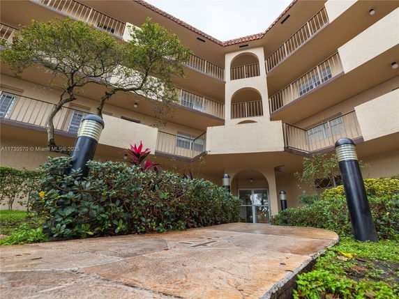 Front view of a multi-story building with balconies and entrance.