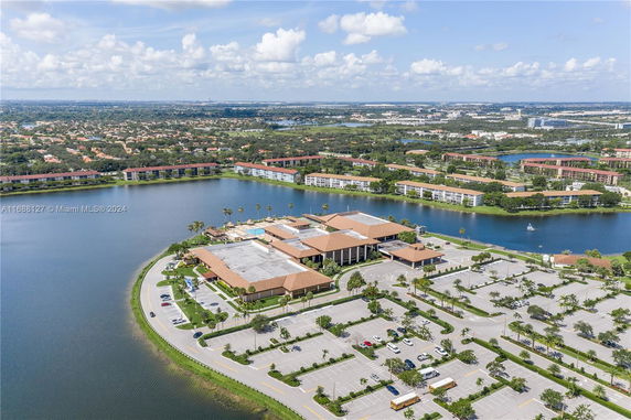 Aerial view of a building complex surrounded by water and residential areas.
