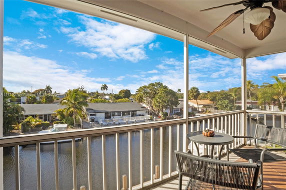 Balcony view overlooking trees and a body of water.
