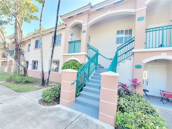 Front view of a two-story residential building with stairs leading to the upper floor.