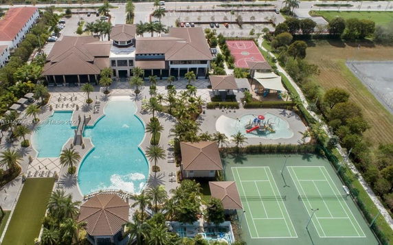 Aerial view of a recreational facility with a swimming pool, tennis courts, and a basketball court.