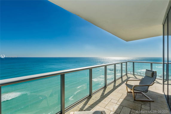 Balcony view overlooking the ocean with a clear blue sky.