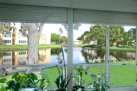 View from a window showing a pond and nearby buildings.