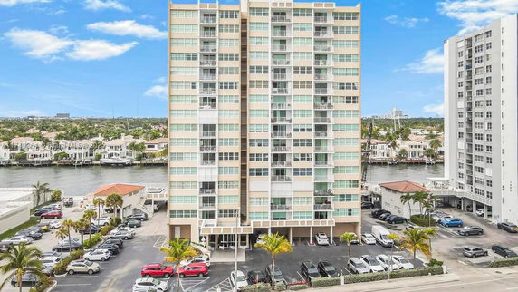 Front view of a tall apartment building with multiple balconies.