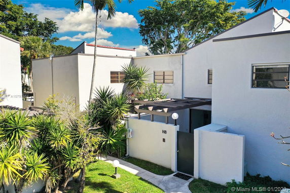 Front view of a modern two-story building with flat roof and white exterior walls.