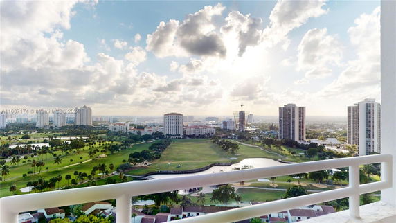 Panoramic view of a cityscape with several high-rise buildings and a golf course in the foreground.