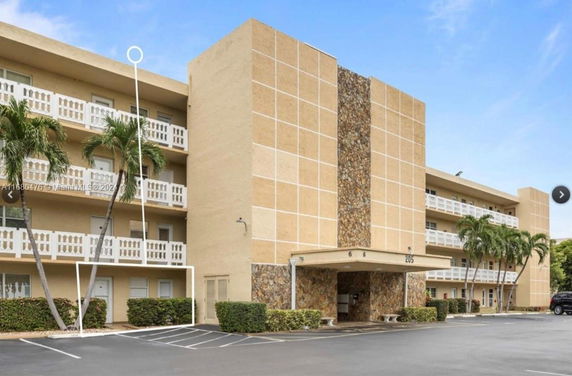 Front view of a four-story apartment building with balconies.