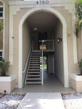 Front view of a building entrance with stairs and an archway.