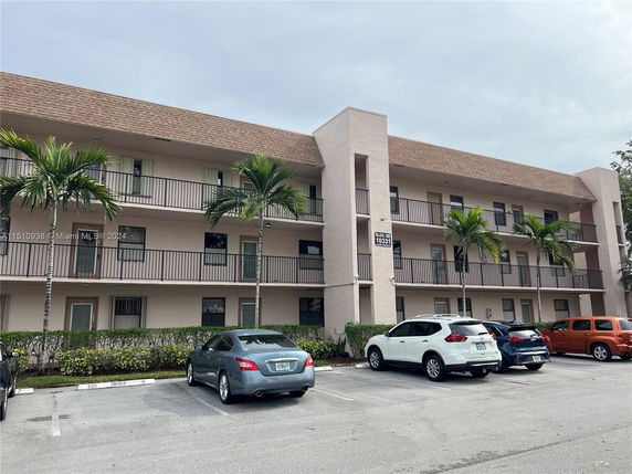 Front view of a three-story apartment building with balconies.