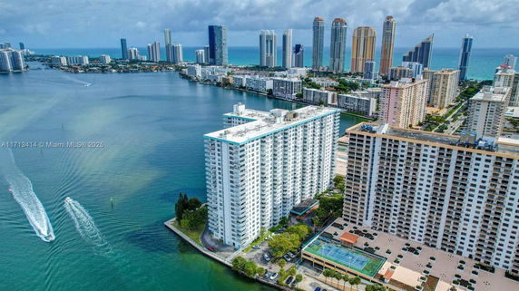 Panoramic view of waterfront high-rise apartment buildings with a backdrop of the city and ocean.