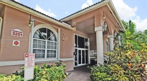 Front view of a clubhouse with large windows and pillars.
