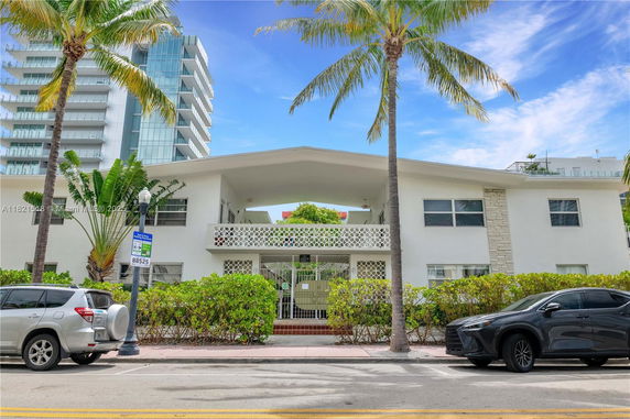 Front view of a two-story building with a distinctive design and gated entrance.