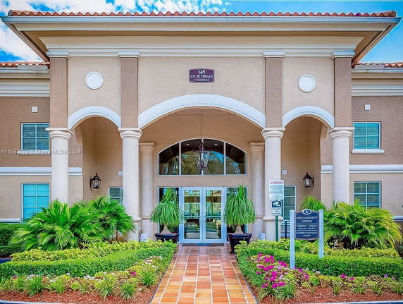 Front view of a building with large pillars and arched entrance.