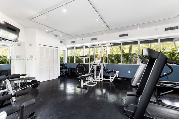Indoor gym area with exercise equipment and large windows.