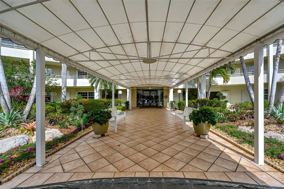 Front view of a building with a covered walkway and garden area.