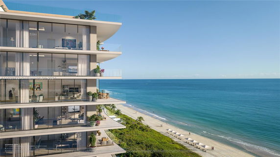 Side view of a modern multi-story beachfront building with large glass windows and balconies overlooking the ocean.