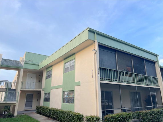Front view of a two-story building with a green and beige color scheme.