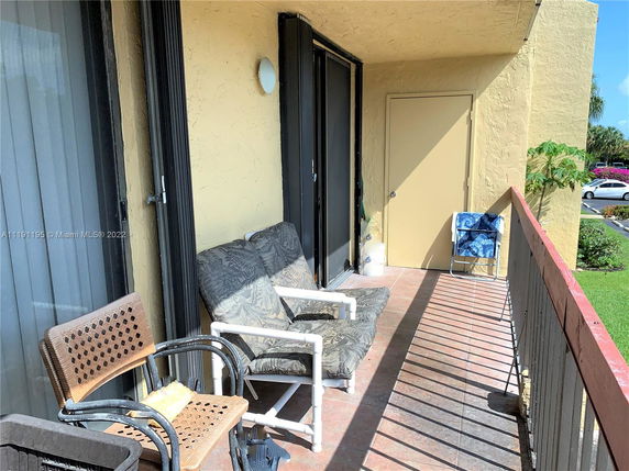 Balcony view with outdoor seating and railing.