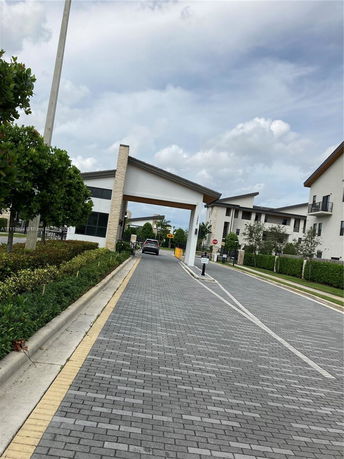 Entrance view of a residential complex with a driveway leading to buildings.