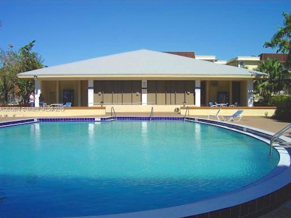 Outdoor swimming pool in front of a single-story building.