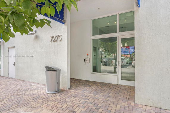 Front view of a building entrance with glass doors and a visible address number.