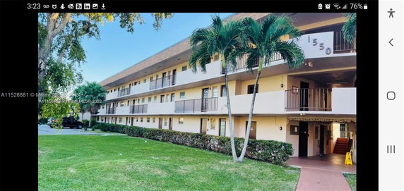 Front view of a multi-story residential building with external walkways and balconies.