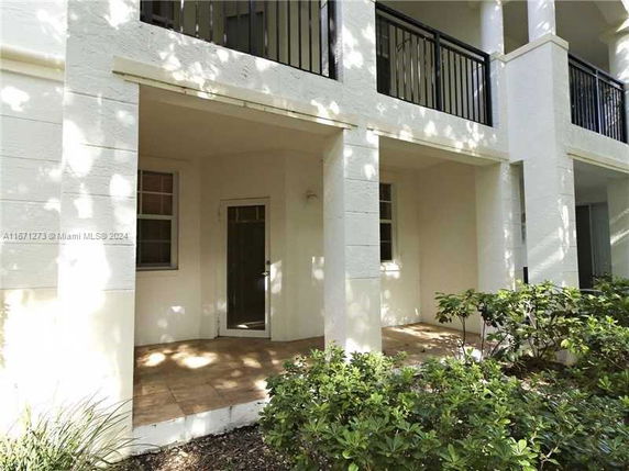 Front view of a building with a patio and railing above.