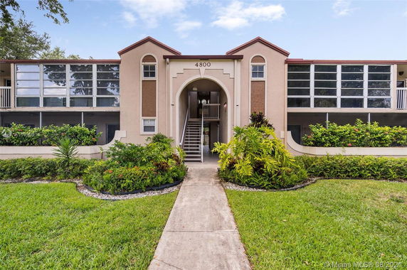 Front view of a two-story building with symmetrical design and greenery.