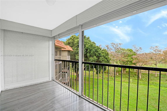 View of surrounding greenery from a balcony with railing.