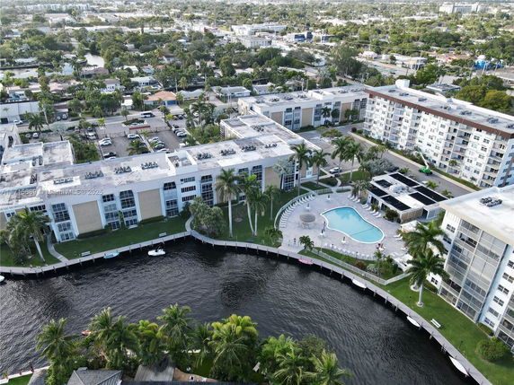 Panoramic view of a residential complex with a swimming pool and canal.