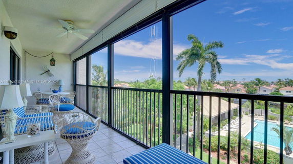 View from a balcony overlooking a pool and surrounding area.