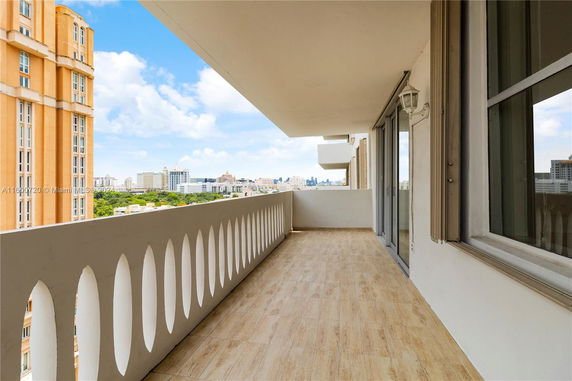Balcony view of a cityscape with tall buildings and blue sky.