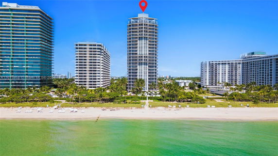 Front view of a tall beachfront building with multiple floors.