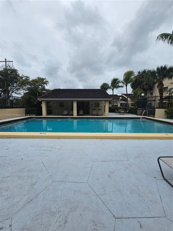 Outdoor swimming pool with a small building nearby.