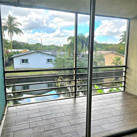 View from a balcony overlooking a canal with houses in the background.