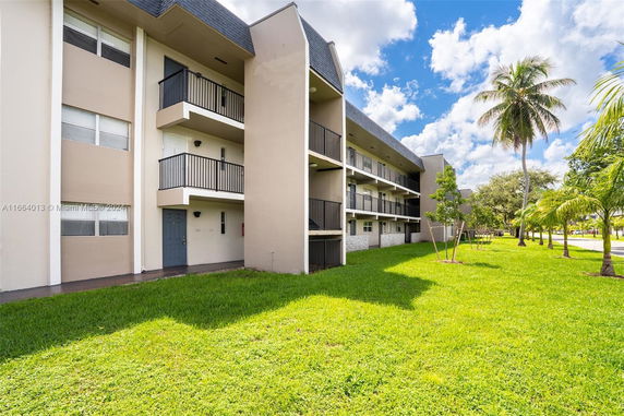 Front view of a three-story apartment building with balconies.