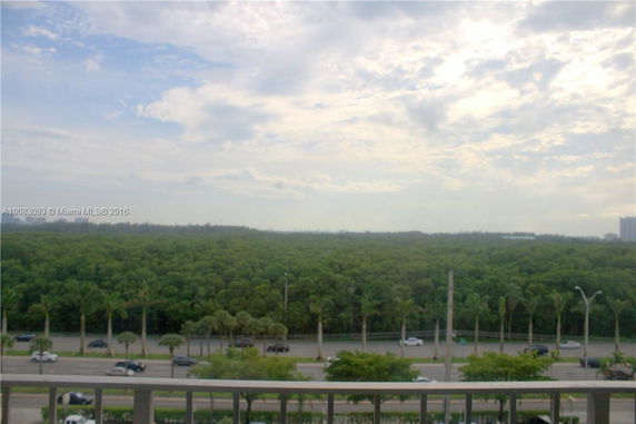 Panoramic view from a building showing a distant view of trees and sky.