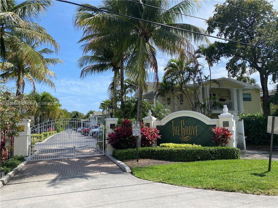 Front view of a gated entrance to a residential complex with a sign reading 'The Grove'.